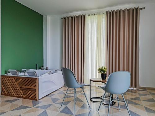 a bathroom with a tub and two chairs at Hotel Arbóreo Doradal in Doradal
