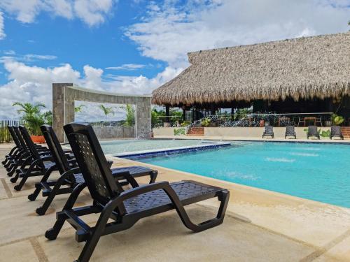 a group of chairs sitting next to a swimming pool at Hotel Arbóreo Doradal in Doradal