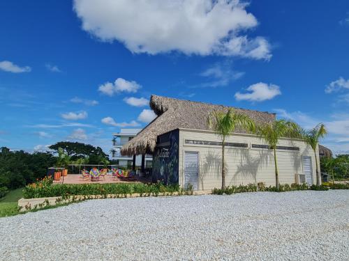 a building with a thatched roof on a gravel road at Hotel Arbóreo Doradal in Doradal