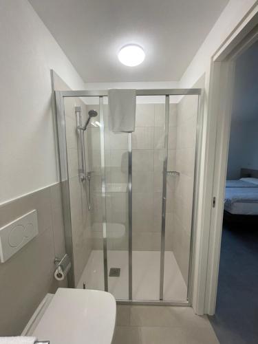 a shower with a glass door in a bathroom at Hotel della Stazione in Maroggia