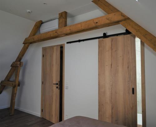 a barn door in a loft conversion with wooden beams at De Sint-Antoniushoeve in Zonnebeke
