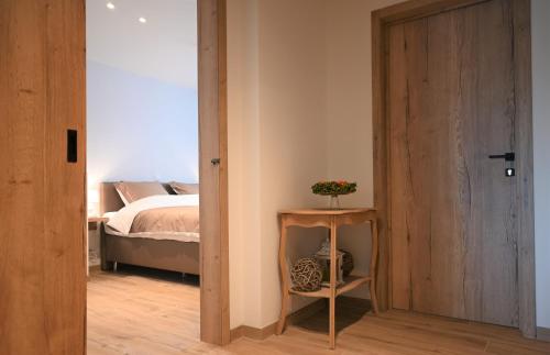 a bedroom with a bed and a door with a table at De Sint-Antoniushoeve in Zonnebeke