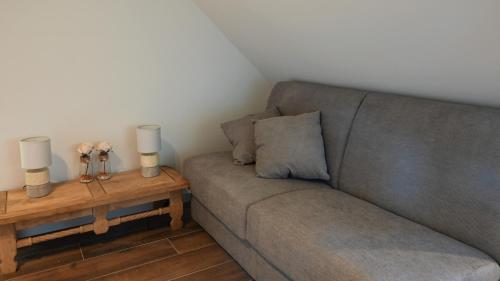 a living room with a gray couch and a table at De Sint-Antoniushoeve in Zonnebeke