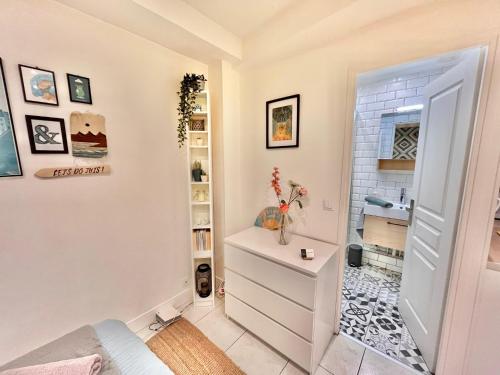 Cette chambre comprend une commode blanche et une salle de bains. dans l'établissement Studio aux Portes de Paris - ACCES DIRECT STADE DE FRANCE, à Clichy