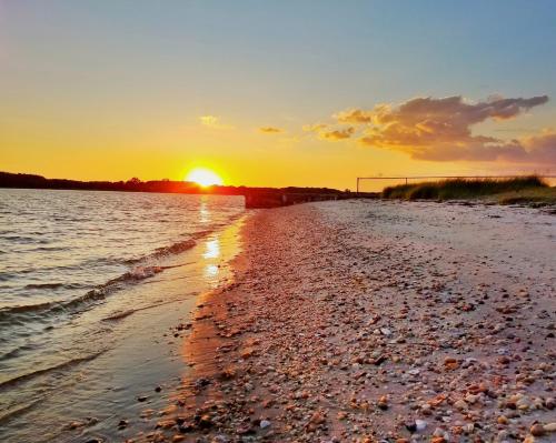 una puesta de sol en la orilla de una playa en Sandaway Suites & Beach, en Oxford