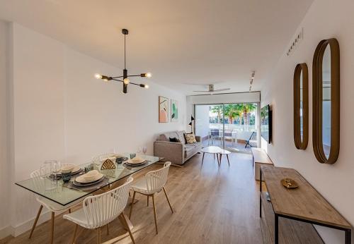 uma sala de jantar e sala de estar com mesa e cadeiras em Homity Exclusive Playa Granada Beach & Golf - Mar de Astrid em Motril