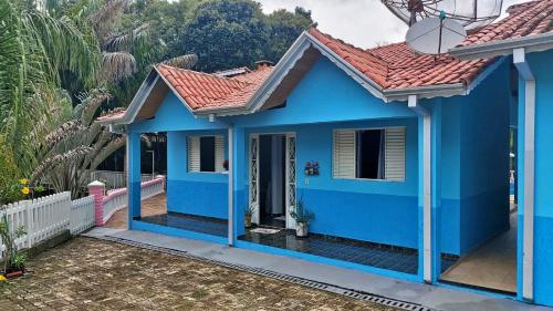 a blue house with a red roof at Pousada Vilarejo de Minas in Itapeva