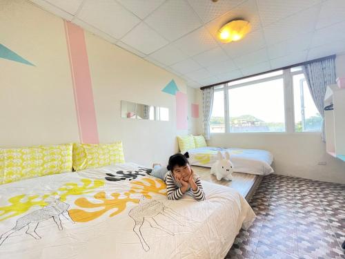 綠島鄉的住宿－夏卡爾民宿，一位年轻女孩躺在卧室的床上