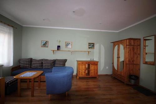 a living room with a blue couch and a table at Penzion Olga in Mariánské Lázně