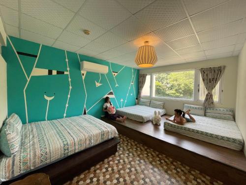 2 niños sentados en el suelo en una habitación con 3 camas en Shiacare Hostel, en Isla Verde