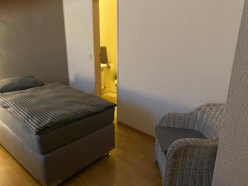 a room with a couch, chair and a lamp at Pension Pagalies in Düsseldorf
