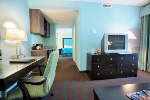 Habitación de hotel con TV y sala de estar. en Holiday Inn Hotel & Suites Ocala Conference Center, an IHG Hotel, en Ocala