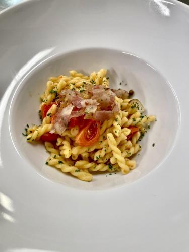a white bowl of pasta with meat and vegetables at Hotel Stella Alpina in Andalo
