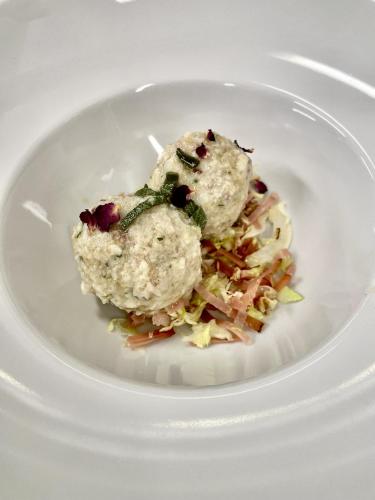 a white plate with food on top of coleslaw at Hotel Stella Alpina in Andalo