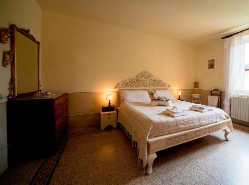 a bedroom with a bed and a dresser and a mirror at Bed and Breakfast Evelina in Lucca