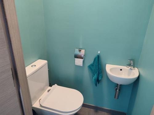 uma casa de banho azul com um WC e um lavatório em Appartement dans un superbe quartier résidentiel em Namur