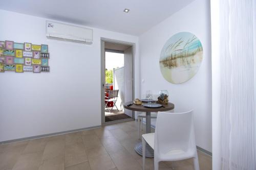 une salle à manger avec une table et des chaises blanches dans l'établissement Studio Alon Ideal pour vos vacances ou sejours pros, à Saint-Cyr-sur-Mer