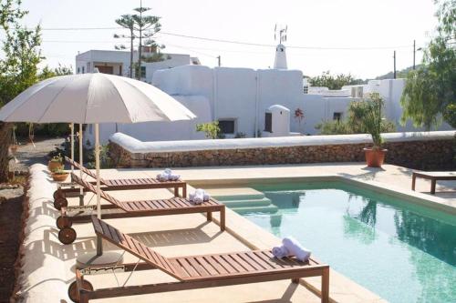 einen Pool mit 2 Liegestühlen und einem Sonnenschirm in der Unterkunft FINCA RELAX IBIZA STILE in San Jose de sa Talaia