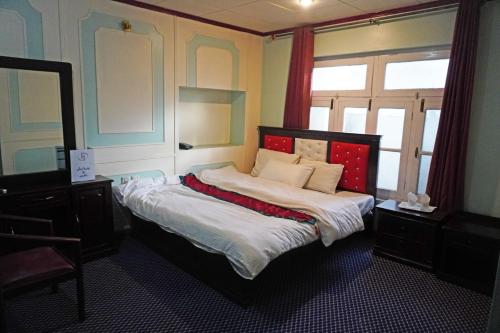 a bedroom with a bed with a large window at Hotel Dewanekhas Skardu in Skardu