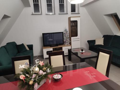 a living room with a table and a tv at WILLA DobraNocka in Szklarska Poręba