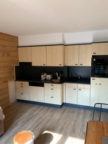 eine Küche mit weißen Schränken und schwarzen Geräten in der Unterkunft Charmant 2 pièces rénové cœur station ISOLA 2000 in Isola 2000