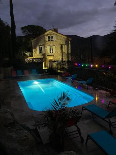 a large blue swimming pool in front of a building at Domaine La Tour - SPA - Jacuzzi - Sauna - Massage - 4 SAISONS - Piscine Chauffée Toute l'année - Heated POOL - 800m City Centre Nyons in Nyons