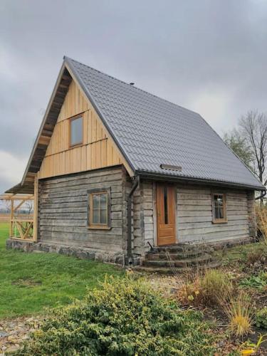 a small wooden house with a black roof at Rīga Mangalsala Cottage with sauna in Riga