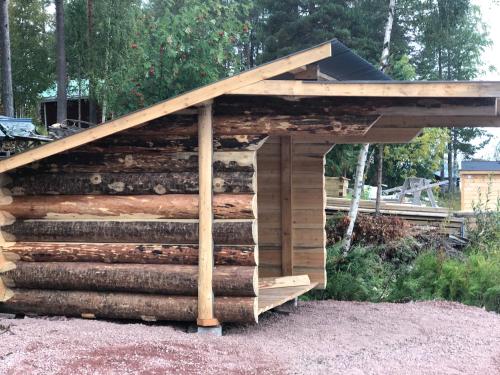 a shed made out of logs with a roof at Lövnäs - Eget Hus utan andra gäster in Sörsjön