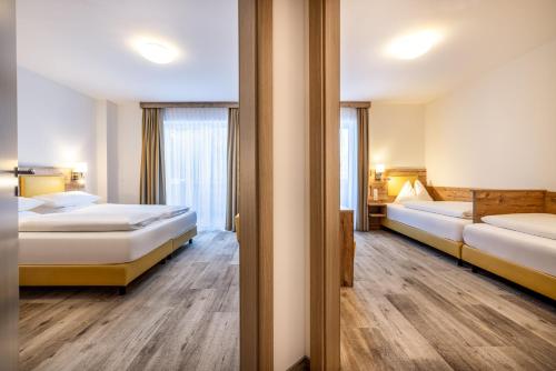 a hotel room with two beds and a window at Der Alpenblick in Sankt Johann im Pongau