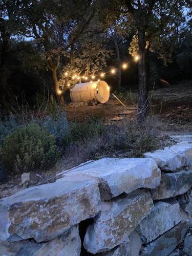 a stone wall with a lit up tank with lights at La Viste - SPA-JACUZZI - MASSAGE- SAUNA - 4 SAISONS - Piscine Chauffée Toute l'année - Heated POOL - 800m City Centre in Nyons