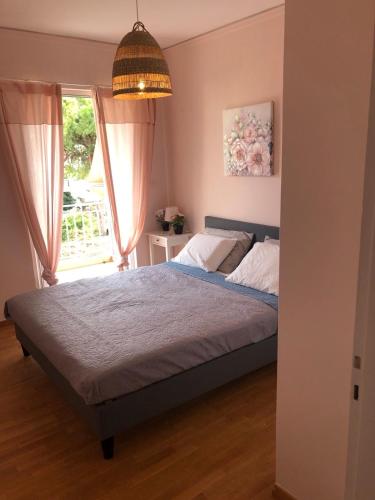 1 dormitorio con cama y ventana en Sun Beach Apartment en Anavissos