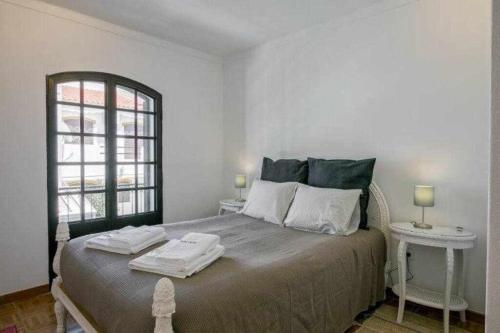 - une chambre avec un grand lit et 2 tables dans l'établissement Vila com piscina e jardim privado, à Altura