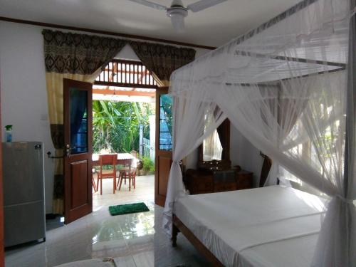 a bedroom with a bed with a canopy at Sisila Villa in Bentota