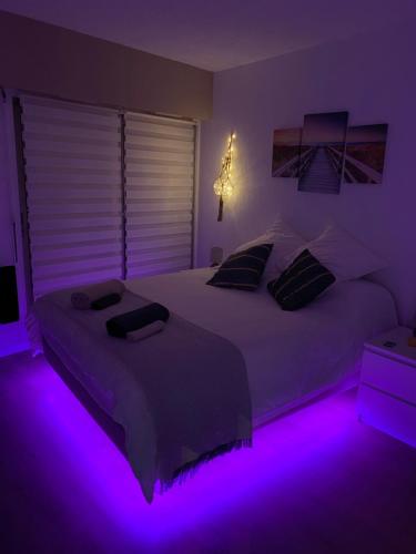a bedroom with two beds with purple lights at Appartement côte d’Azur Plage - piscine - tennis in Villeneuve-Loubet