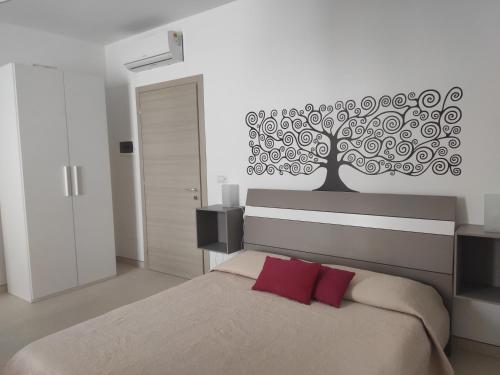 una camera da letto con un grande murale sull'albero di Casa Vacanze Rossini a Porto Cesareo