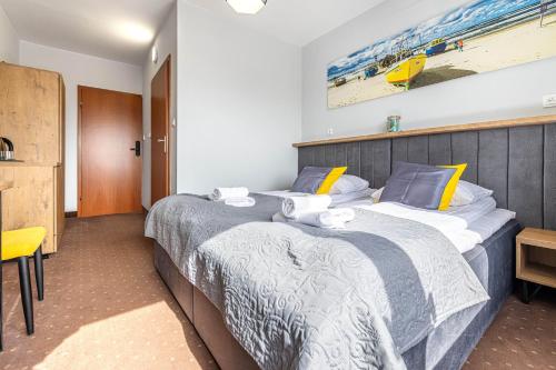 2 Einzelbetten in einem Hotelzimmer mit in der Unterkunft Hotel Krynica in Krynica Morska