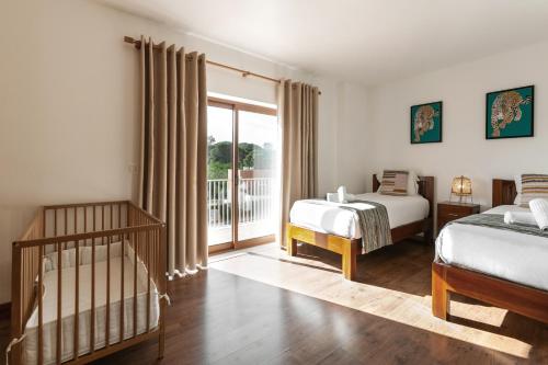 - une chambre avec 2 lits et une porte coulissante en verre dans l'établissement Villa Lantana, à Vau