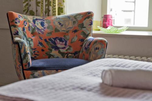 a chair in a room with a table and a window at Hawthorn Farm Guest House in Buxton