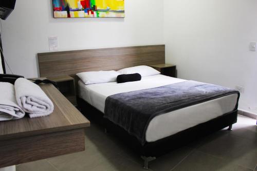 a bedroom with a large bed with a wooden headboard at Hotel America 52 in Rionegro