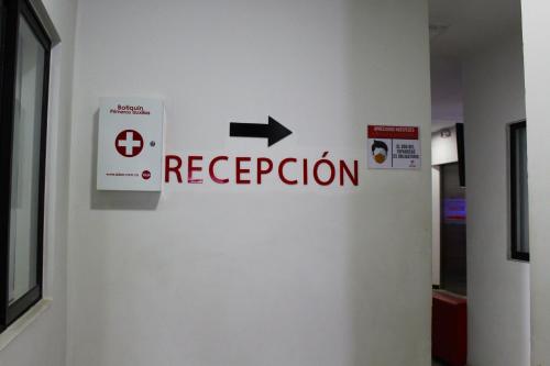 una señal que dice recepción en una pared en Hotel America 52, en Rionegro