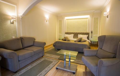 a hotel room with a bed and two chairs and a table at Spa-Hotel Myslyvskiy Dvir in Kyiv