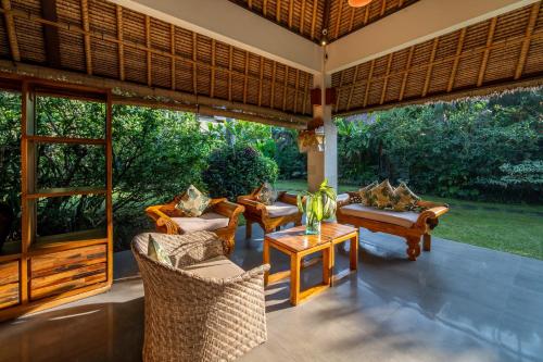 an outdoor living room with couches and a table at The Hidden Paradise Ubud - CHSE Certified in Ubud
