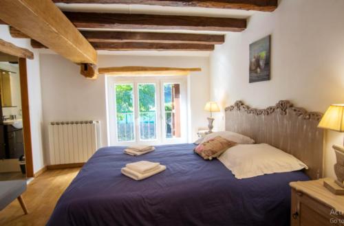 a bedroom with a blue bed with two towels on it at Villa confortable à Carlux avec piscine privée et jardin in Carlux