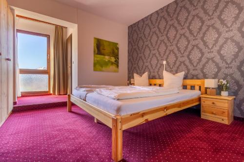 a bedroom with a bed with a purple carpet at Hotel Pension Löwen in Sulz in Sulz