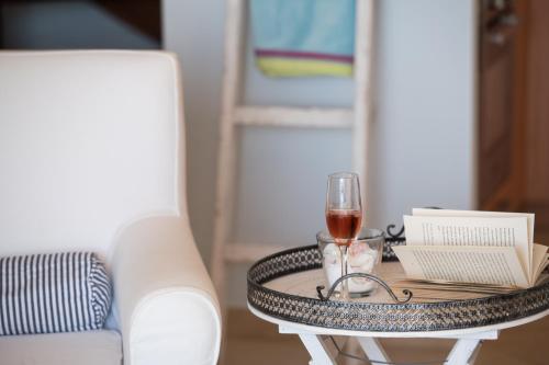 a table with a glass of wine and a book at Villa Pasithea - breathtaking seaviews, infinity pool, privacy, close to the beach in Nydri