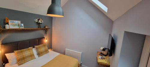 a bedroom with a bed and a television in it at Ring O Bells Hinton Blewett in Bristol