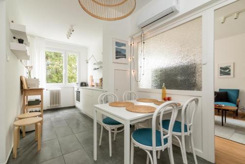 a kitchen and dining room with a table and chairs at Allé Apartman Keszthely in Keszthely