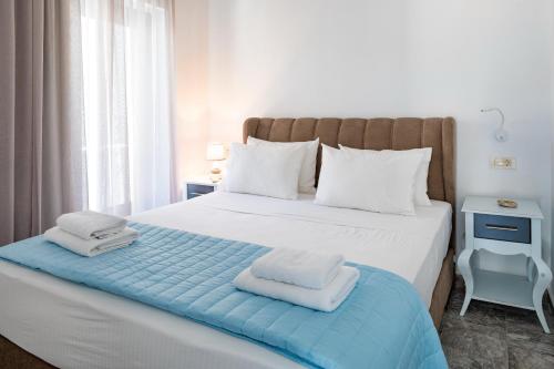 a bedroom with a large white bed with towels on it at Plori - Molos Apartments in Loutro