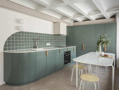 una cocina con armarios azules y una mesa blanca en Apartamento exclusivo en el centro de valencia con preciosa terraza, en Valencia