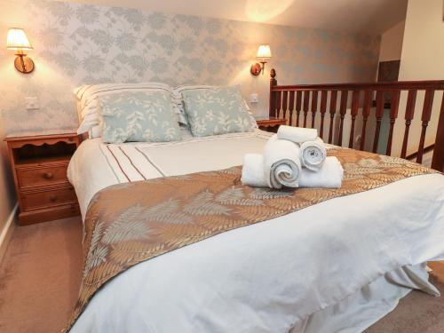 een slaapkamer met een groot bed met handdoeken erop bij Coach House Cottage in Carnforth